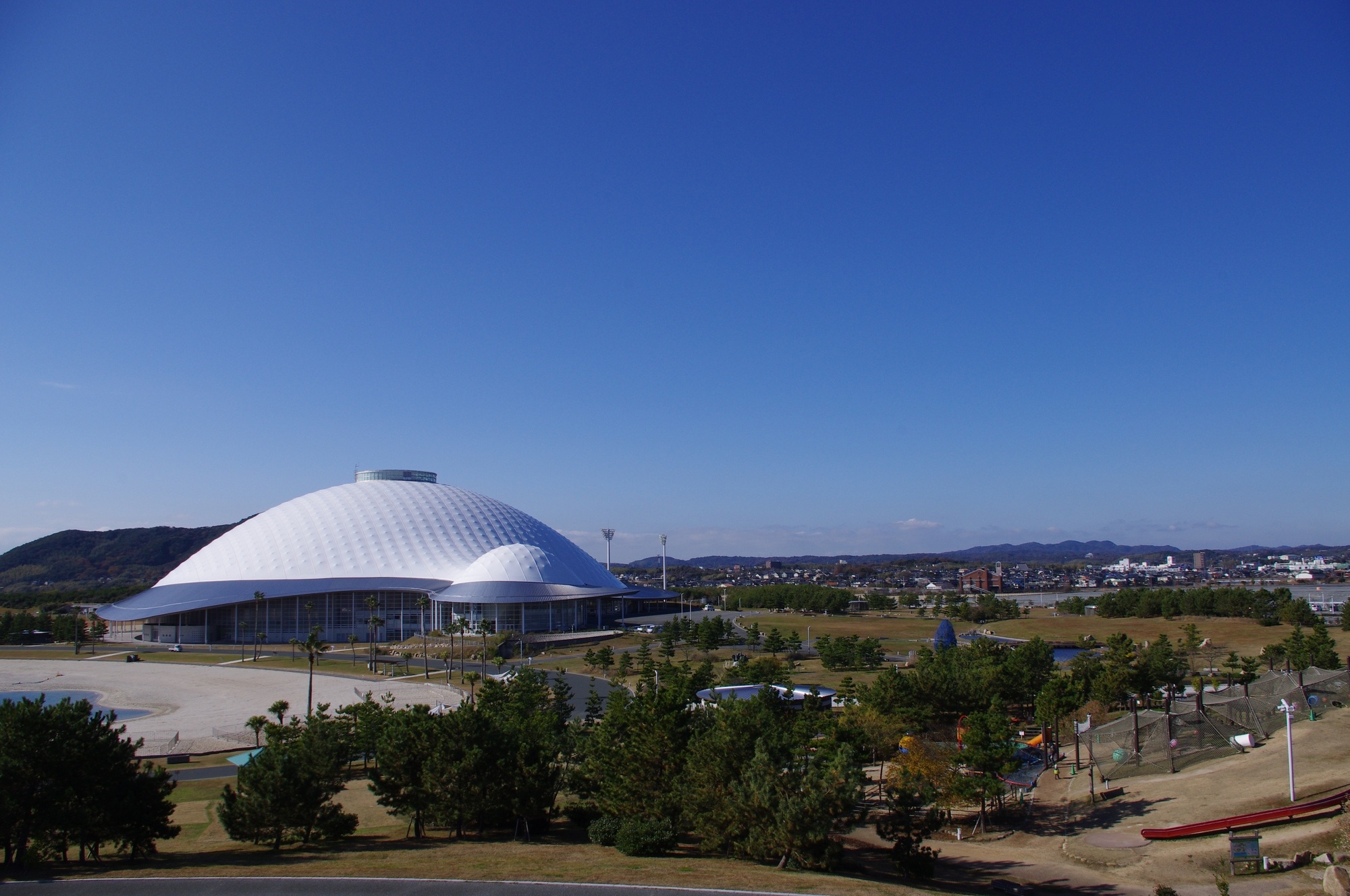 青い空と海に囲まれた山口きらら博記念公園のきららドーム全景